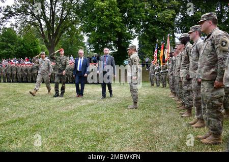 Der Befehlshaber des 18. Kampfbataillons für Nachhaltigkeit, USA Oberstleutnant John R. Abella, Vordergrundlinke, und Vertreter der deutschen Armee und lokaler Gemeinschaften inspizieren die Truppen auf dem Feld während einer Vereidigung der deutschen Armee und der fünfzehnjährigen Partnerschaftszeremonie des Bataillons mit der Gemeinde Freihung, Deutschland, am 22. Juni 2022. Stockfoto