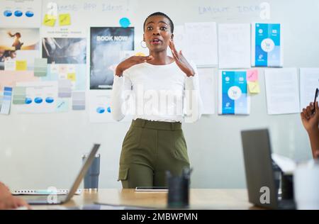 Die produktivsten Teams werden von leidenschaftlichen Führungskräften geleitet. Eine junge Geschäftsfrau, die eine Präsentation vor Kollegen in einem modernen Büro hält. Stockfoto