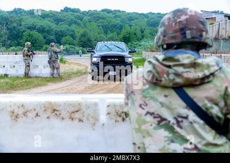 USA Armeesoldaten, die der 1109. Theater Aviation Support Maintenance Group, Connecticut Army National Guard, zugewiesen wurden, Bewegung für ein Fahrzeug, um an einem Eintrittskontrollpunkt anzuhalten, oder ECP, außerhalb einer simulierten vorwärts fahrenden Operationsbasis, oder FOB, im Stones Ranch Military Reservation, East Lyme, Connecticut, 22. Juni 2022. ECPs sind ein System von Checkpoints, die den Eingang zu einem FOB steuern. Stockfoto