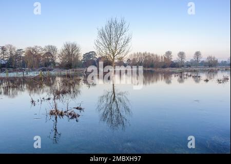 Burgate, Fordingbridge, Hampshire, England, Großbritannien, 21. Januar 2023, Wetter: Überschwemmungen und Frost bei Sonnenaufgang auf dem Fußweg des Avon-Tals durch Ackerland in Richtung New Forest. Die Route ist aufgrund des Hochwassers unpassierbar. Kredit: Paul Biggins/Alamy Live News Stockfoto