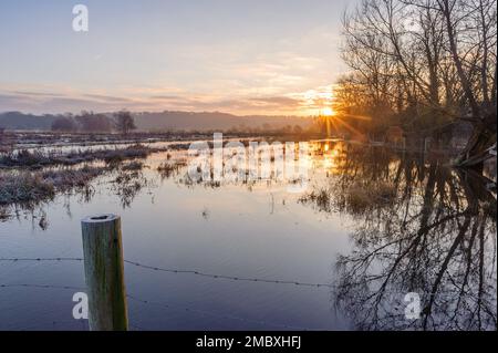 Burgate, Fordingbridge, Hampshire, England, Großbritannien, 21. Januar 2023, Wetter: Überschwemmungen und Frost bei Sonnenaufgang auf dem Fußweg des Avon-Tals durch Ackerland in Richtung New Forest. Die Route ist aufgrund des Hochwassers unpassierbar. Kredit: Paul Biggins/Alamy Live News Stockfoto