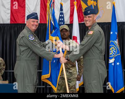 Oberst Andrew Campbell, 374. Offizier der Luftschleuse, gibt einen Guidon an Generalleutnant Ricky Rupp, USA Streitkräfte Japan und 5. Luftwaffenkommandant, während der Zeremonie zum Kommandowechsel im Luftwaffenflügel 374., 23. Juni 2022, am Luftwaffenstützpunkt Yokota, Japan. Der Tod des Guidons bedeutet, dass Campbell das Kommando über die 374. AW abgibt. Stockfoto