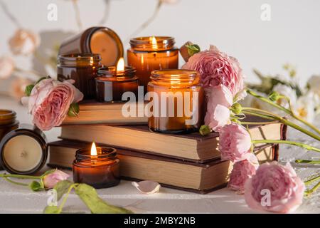 Ein Set verschiedener Duftkerzen in braunen Glasgefäßen. Handgemachte Duftkerze. Sojalkerzen brennen in einem Glas. Aromatherapie und entspannen Sie sich im Spa und zu Hause. Feuer in braunem Glas. Stockfoto