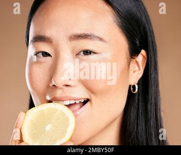 Asiatische Frau, Studioporträt und Zitrone für Lächeln, gesundes kosmetisches Leuchten auf die Gesundheit der Haut durch den Hintergrund. Japanisches Model, Mädchen und Schönheit für Vitamin C. Stockfoto