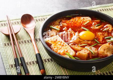 Sundubu jjigae oder Soft Tofu Eintopf, ist ein traditionelles koreanisches Gericht, das aus seidig weichem, ungedicktem Tofu hergestellt wird, das in einer würzigen und geschmackvollen Brühe auf der Nahtstelle überzogen ist Stockfoto