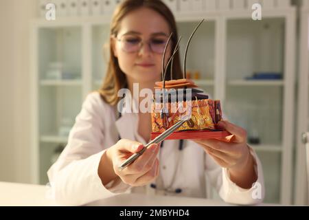 Arztliche Trichologin zeigt künstliches Modell menschlicher Haut mit Haar in der klinischen Nahaufnahme Stockfoto