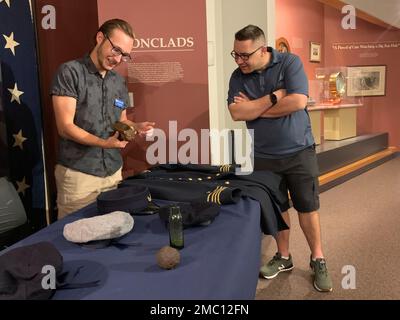 Ethan Dykes, ein Praktikant im Hampton Roads Naval Museum, spricht mit Besuchern in der Galerie des Bürgerkriegs über Artefakte und Gegenstände im Zusammenhang mit der USS Cumberland. Cumberland sank während eines Engagements mit dem ironclad ram der Konföderierten, CSS Virginia, am 8. März 1862. Das Museum ist das offizielle Archiv für Artefakte, die aus dem Wrack der USS Cumberland geborgen wurden. Stockfoto