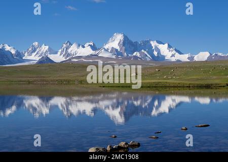 Auch die kaschaalen Berge spiegeln sich in einem alpinen See wider, die Tian Shan-Gebirgskette nahe der chinesischen Grenze, die Naryn-Region, Kirgisistan Stockfoto