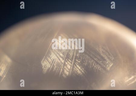 Detail einer gefrorenen Seifenblase, aufgenommen in meinem Garten bei Sonnenaufgang, Kanton Bern, Schweiz Stockfoto