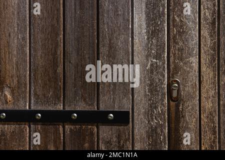 Detail einer alten rustikalen Holztür mit Riegel Stockfoto