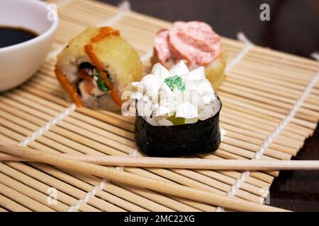 Sushi rollt auf einer Bambusmatte Stockfoto