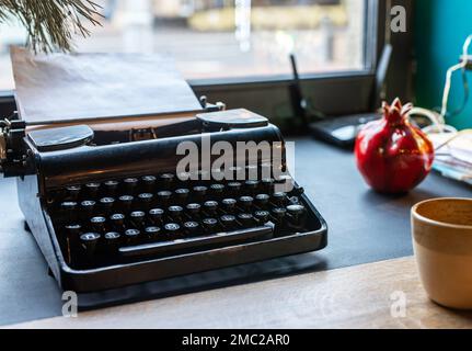 Alte Schreibmaschine, Schreibmaschine auf dem Schreibtisch im Café. Hochwertiges Foto Stockfoto