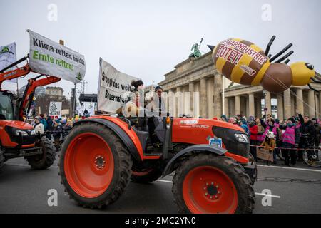 Berlin, Deutschland. 21. Januar 2023. Während einer Demonstration der Organisation „Wir haben es satt!“ fährt ein Traktor vor dem Brandenburger Tor. "Gutes Essen für alle - statt Profit für ein paar." Kredit: Christophe Gateau/dpa/Alamy Live News Stockfoto