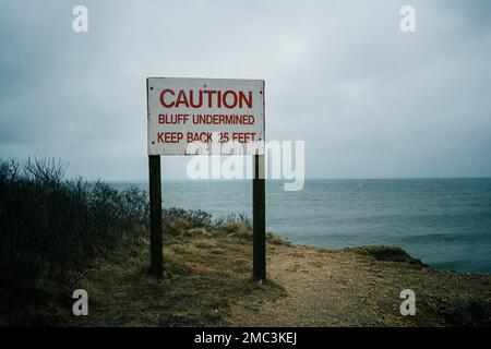 Schild mit unterminierten Klippen im Camp Hero State Park, Montauk, New York Stockfoto