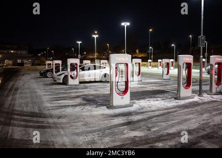 Göteborg, Schweden - dezember 09 2022: Autos laden nachts an Tesla Supercharger auf Stockfoto