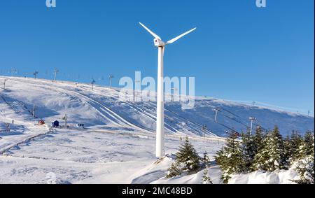 Lecht Ski Centre Cairngorms National Park Schottland die Snowy Owl and Grouse Runs und eine große Windturbine im Schnee Stockfoto