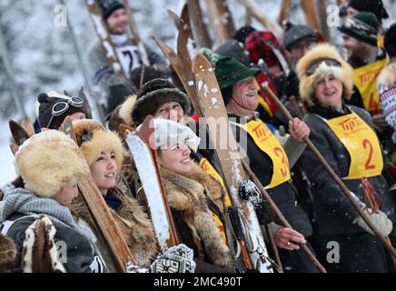 Bayern, Deutschland. 21. Januar 2023. 21. Januar 2023, Bayern, Krün: Teilnehmer mit ihren Holzskiern warten auf den Beginn des Skirennens „Nostalski“ am Barmsee Lift. Mit alten Holzskiern und Schnürsenkel aus Leder, zumindest aus dem letzten Jahrhundert, beginnen die Teilnehmer mit einem lustigen Rennen. Foto: Angelika Warmuth/dpa Credit: dpa Picture Alliance/Alamy Live News Stockfoto