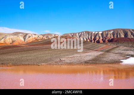 Roter Stausee in rot gestreiften Bergen. Khizi-Region. Aserbaidschan. Stockfoto