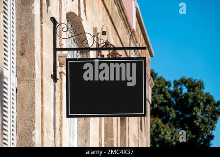 An der Wand des Ladens auf der Straße hängt ein leeres Schild Stockfoto