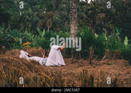 Männer können sich mit Mobilgeräten in Field, Ubud, Bali Indonesia entspannen Stockfoto