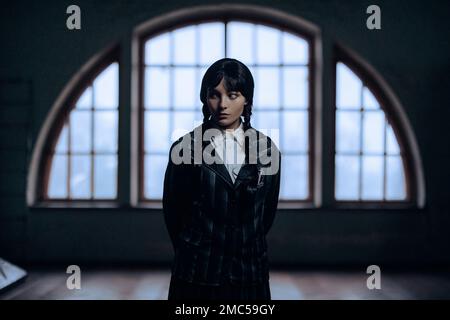 Dnipro, Ukraine - 30. Dezember 2022: Cosplayer Girl im Bild von Wednesday Addams aus der gleichnamigen Comedy Horror-Serie 'Wednesday' Posen im Saal gegen Stockfoto