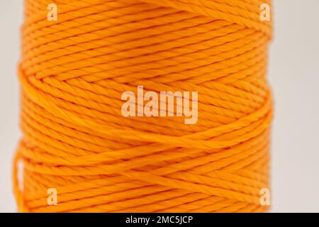 Eine Rolle synthetischer orangefarbener Faden Stockfoto