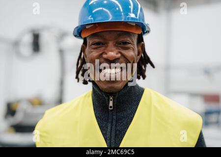 Glücklicher afrikanischer Ingenieur in der Automatisierungsfabrik - Industriekonzept Stockfoto