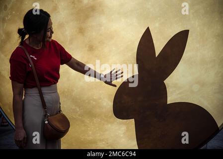 Bangkok, Thailand. 21. Januar 2023. Eine Frau posiert für ein Bild neben einer leichten Skulptur im Hasenmotiv während der Neujahrsfeier des Mondes in Bangkoks Chinatown. (Foto: Peerapon Boonyakiat/SOPA Image/Sipa USA) Guthaben: SIPA USA/Alamy Live News Stockfoto