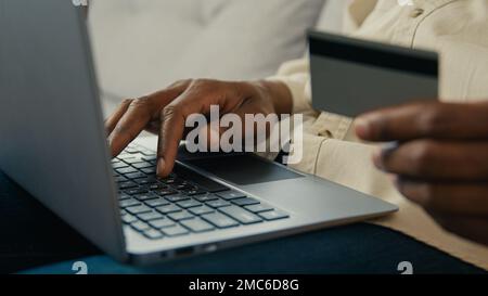 Nahaufnahme männliche Hände männlicher Käufer, der eine Kreditkarte besitzt und mit einer elektronischen Bankanwendung im Online-Shop auf bezahlt Stockfoto