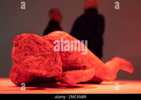 Ein Paar in einem Museum hinter einem Gipsverband eines lügenden Opfers, gefunden in Pompeji, beleuchtet mit roten Lampen, um den Ausbruch des Vulkans zu vermuten Stockfoto