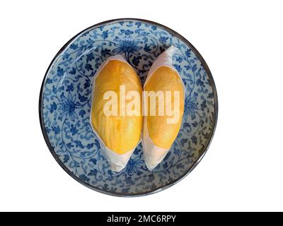 Zwei goldgelbe Fleischsorten von Durian, eingewickelt mit weißem Papier auf dem blauen antiken Teller, König der Früchte, natürliche Form und Form, isoliert, weiß Stockfoto