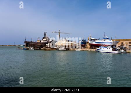 Docks, Kräne und Fischerboote im Hafen von Marsala, einer großen Stadt im Westen Siziliens. Stockfoto