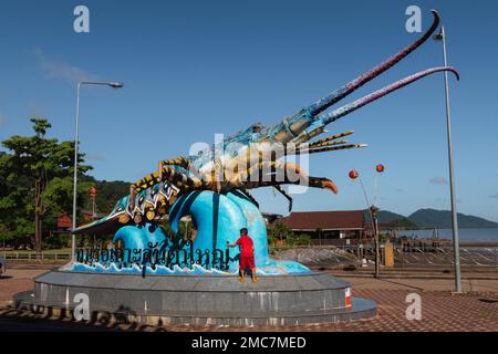 Hummerstatue am Ko-Lanta-Pier in der Altstadt, mit einem Kind, das rot darauf klettert. Ko Lanta, Krabi, Thailand. 29. November 2022. Stockfoto