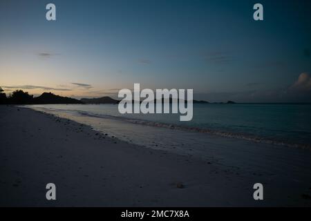 Blick am Abend entlang des langen Strandes von Anse Volbert. Stockfoto