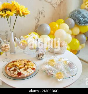 Köstliches süßes Weihnachtsbuffet mit Cupcakes, Baiser und anderen Desserts. Hintergrund von Ballons Stockfoto