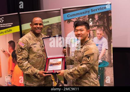 USA Oberstleutnant der Armee, Major Benjamin Lemon (links), USA Army Garrison Humphreys Senior Encelled Leader, überreicht einen Preis an einen Soldat, der IMCOM beim United States Army Garrison Humphreys Better Opportunities for Single Soldiers (BOSS)-Programm vertritt 3. Quarter Awards Ceremony at Humphreys Family Theater für die höchste Teilnahme am BOSS Water Balloon Bonanza, Juni 28, 2022. Die Gewinner wurden für ihre Exzellenz, ihr Engagement und ihre Leistungen im Zusammenhang mit dem BOSS-Programm ausgezeichnet. Stockfoto