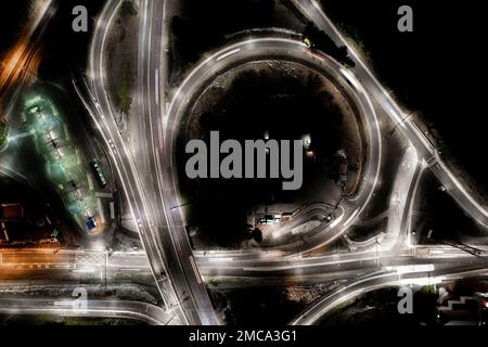 Nacht City Street Highway, Kreuzung , Bushaltestelle, überhöhter Stadtverkehr, schneller Verkehr, Belebte Straße, Autos Lichtstreifen, Transportnetz, Straße. Stockfoto