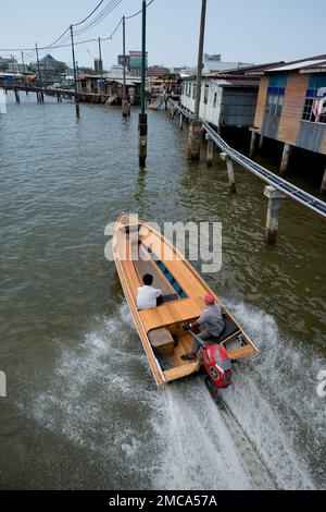 Wassertaxi mit dem Schnellboot, vorbei am Fußweg und an Stelzen in Brunei River, Water Village (Kampong Ayer), Bandar Seri Begawan, Brunei Stockfoto