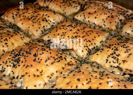 Griechischer traditioneller hausgemachter Spinatkuchen, bereits gebacken und in quadratischen Portionen geschnitten, aus nächster Nähe, angewinkelter Blick Stockfoto