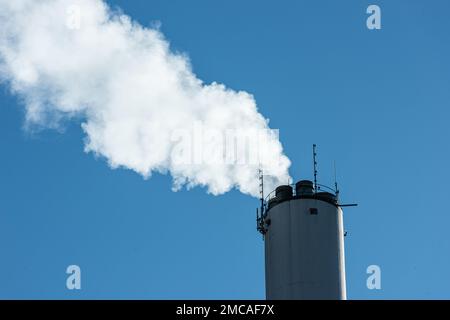 Dampf steigt aus einem hohen Schornstein. Stockfoto