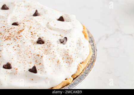 Eine Schokoladenkuchen mit Schokoladenstückchen und Kakao auf Schlagsahne Stockfoto