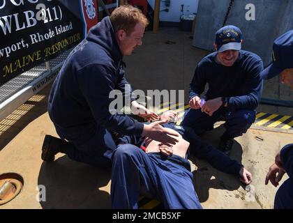 Petty Officer 3. Klasse Nathan Sprock (links) und Petty Officer 1. Klasse Nicholas Loeven (rechts) simulieren die Behandlung einer abdominalen Wunde bei Petty Officer 1. Klasse Eric Enchelmaier während einer Massenverletzten-Übung an Bord der Küstenwache Cutter Oak, 28. Juni 2022. Die Besatzung nimmt sich auf dem Weg zur Teilnahme an der jährlichen Übung Argus Zeit für die Durchführung der Schulung. USA Foto der Küstenwache von Petty Officer 2. Klasse Diana Sherbs. Stockfoto