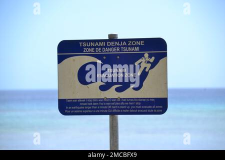 Ein Schild mit Warnung und Tsunami-Informationen am Strand am Ufer in Vanuatu, Hauptstadt von Port Vila Stockfoto