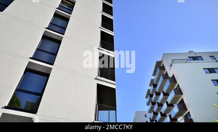 Apartmentgebäude mit hellen Fassaden. Moderne, minimalistische Architektur mit vielen quadratischen Glasfenstern und Balkonen. Stockfoto