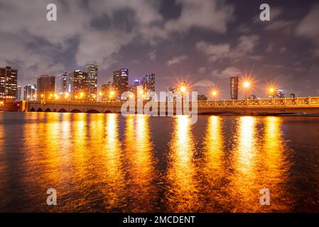 Panoramafoto von Miami bei Nacht. Miami Downtown hinter dem MacArthur Causeway, aufgenommen vom Venetian Causeway. Stockfoto