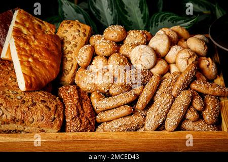 Die Mischung aus verschiedenen frisch gebackenen Broten in einem Holzkorb Stockfoto
