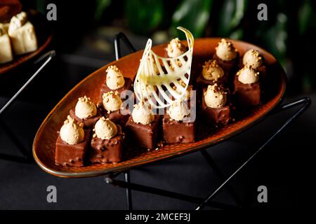 Schokoladenbonbons auf einem braunen Teller. Dekorierte hausgemachte Schokolade Stockfoto