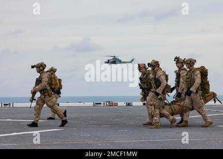 USS Miguel Keith, Südchinesische See (7. Januar 2022) – USA Marine Corps Reconnaissance Marines zugewiesen zu Reconnaissance Company, 13. Marine Expeditionary Unit, verlegen einen simulierten Verletzten auf das Flugdeck, Januar 7. Vorausschauende, schnelle Reaktionsfähigkeit und integrierte Fähigkeiten der Marine und des Marine Corps erweitern die Möglichkeiten, die das Team des Marine-Marine-Corps den Befehlshabern der gemeinsamen Streitkräfte bietet. Die 13. Marine Expeditionary Unit wird auf die Makin Island Amphibious Ready Group gebracht, die aus dem Amphibienschiff USS Makin Island (LHD 8) und den Amphibienschiffen USS John P. Murtha (LPD 26) und den USA besteht Stockfoto