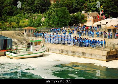 Eine Menge Touristen versammelt sich für die Bootsfahrt „Maid of the Mist“, während sie blaue Ponchos in Niagara Falls, Kanada, tragen Stockfoto