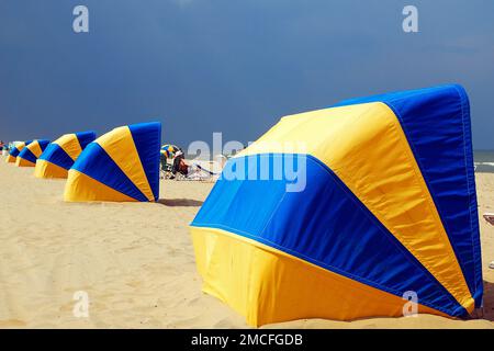 Strandhütten stehen bereit, um die ultravioletten Sonnenstrahlen und einen sich nähernden Sturm in Virginia Beach an einem Sommerurlaub zu bewachen Stockfoto